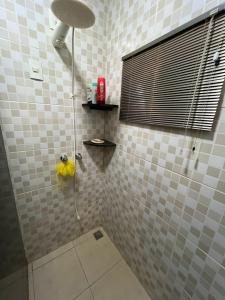 ein Bad mit einer Dusche mit einem Duschkopf in der Unterkunft AconcheganteQuarto in Rio Verde