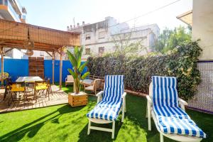 two chairs and a table in a yard with grass at The Beach House Paradise by Hello Homes Sitges in Sitges