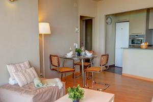 uma sala de estar com uma mesa e um sofá em La Gioia 3 by Hello Homes Sitges em Sitges