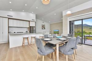 a kitchen and dining room with a table and chairs at Somerville Wines Lux Escape 3-Bedroom Cottage Near Broke Wineries in Broke