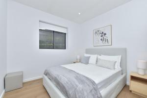 a white bedroom with a large bed and a window at Somerville Wines Lux Escape 3-Bedroom Cottage Near Broke Wineries in Broke +16 photos