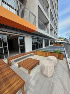 a patio with benches and tables on a building at Apto no Bessa 100 metros da praia in João Pessoa