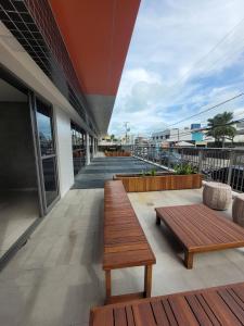two wooden benches sitting on a balcony of a building at Apto no Bessa 100 metros da praia in João Pessoa