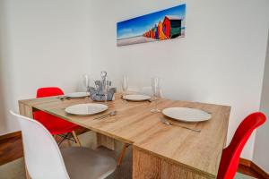 een eettafel met rode stoelen en een houten tafel bij Seaside April Apartment by Hello Homes Sitges in Sitges