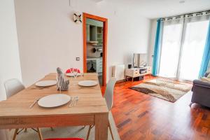 einen Esstisch und Stühle im Wohnzimmer in der Unterkunft Seaside April Apartment by Hello Homes Sitges in Sitges