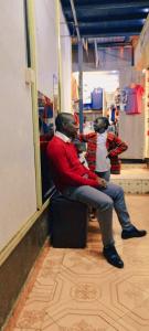 a man and child sitting on a bench in a store at Pavleena Residence 2 Bedrooms unit in Nanyuki