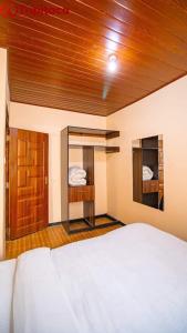 a bedroom with a white bed and a wooden ceiling at Pavleena Residence 2 Bedrooms unit in Nanyuki