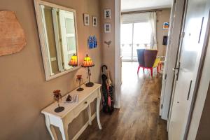 ein Zimmer mit einem Spiegel und einem Tisch mit Blumen darauf in der Unterkunft Sweet Raffaello Beach by Hello Homes Sitges in Sitges