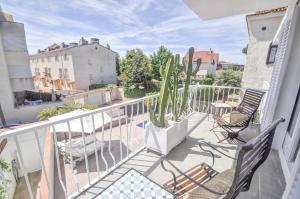 einen Balkon mit zwei Stühlen und einem Kaktus darauf in der Unterkunft The Luxor Apartment by Hello Homes Sitges in Sitges