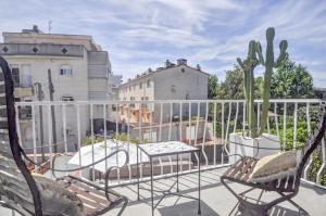 einen Balkon mit Stühlen, einem Tisch und einem Kaktus in der Unterkunft The Luxor Apartment by Hello Homes Sitges in Sitges