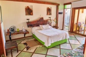 ein Schlafzimmer mit einem Bett und einem Tisch in einem Zimmer in der Unterkunft Finca Turística La Casa que Canta in Quimbaya
