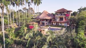 una casa en una colina con palmeras en Finca Turística La Casa que Canta, en Quimbaya