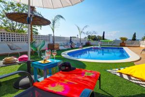 - une piscine avec une table et un parasol dans l'établissement Villa Talaya by Hello Homes Sitges, à Sant Pere de Ribes