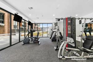 - une salle de sport avec plusieurs tapis de course et appareils de cardio-training dans l'établissement Spacious 1-Bed Apartment with Gym, BBQ & Parking, à Kingston 