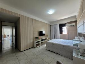 - une chambre avec un lit et une télévision dans l'établissement Edifício Monte Sinai, à Cabedelo