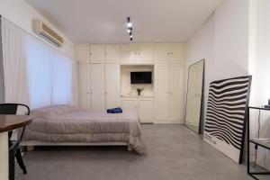 1 dormitorio con 1 cama y TV. en Apartamento zona Embajada USA - Plaza Italia by Debarrio Aparts en Buenos Aires