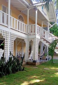a large white house with a porch and hammocks at Looking Good Surf House San Juan del Sur in San Juan del Sur