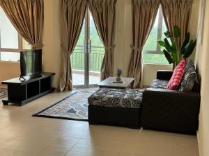 a living room with a couch and a flat screen tv at Desaru Private Beach Family Suite Big Pool D0513 in Bandar Penawar +25 photos