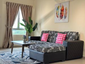 a living room with a couch and a table at Desaru Private Beach Family Suite Big Pool D0513 in Bandar Penawar