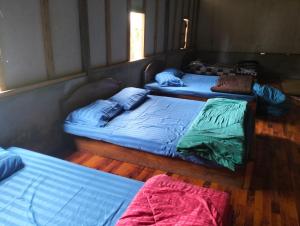 a group of three beds in a room at Shared Happy Farm in Ban Nongboua
