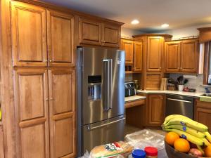 eine Küche mit Holzschränken und einem Kühlschrank aus Edelstahl in der Unterkunft Hershey retreat 4 in Harrisburg