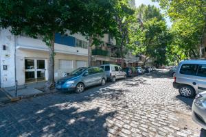 una calle adoquinada con coches aparcados en ella en Apartamento zona Embajada USA - Plaza Italia by Debarrio Aparts en Buenos Aires