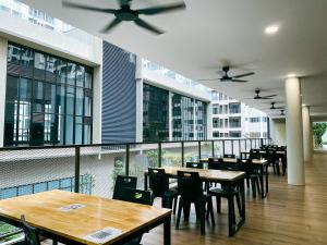 a restaurant with wooden tables and chairs and windows at Family 2 Rooms w/t Internet Nilai Youth City A07 in Nilai