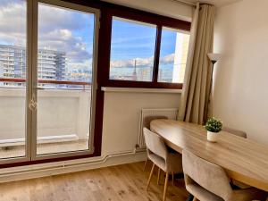 comedor con mesa y ventana grande en Suite Bella vista : piscine & vue panoramique, en París