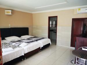 1 Schlafzimmer mit 2 Betten und einem Tisch in der Unterkunft Hotel Fundacooedumag Rodadero in Santa Marta