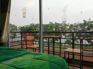 a bedroom with a bed and a balcony with a view at พญาเกสท์เฮ้าส์ in Nakhon Phanom