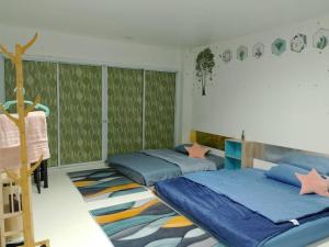Duas camas num quarto com papel de parede verde em พญาเกสท์เฮ้าส์ em Nakhon Phanom