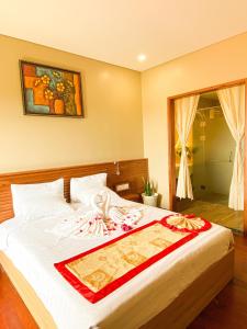 a bedroom with a bed with a red and white blanket at Memories Hotel in Bao Loc