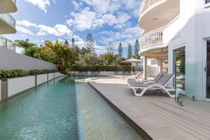 ein Haus mit einem Pool und zwei Liegestühlen in der Unterkunft Sunny 'Beachside' Unit Buddina Resort in Buddina