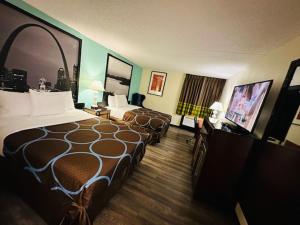 a hotel room with two beds and a flat screen tv at Super 8 by Wyndham Branson Thousand Hills in Branson