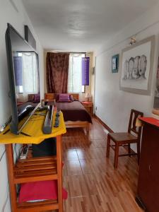 Un dormitorio con una cama y un escritorio con una computadora. en Departamento privado artístico, en La Paz