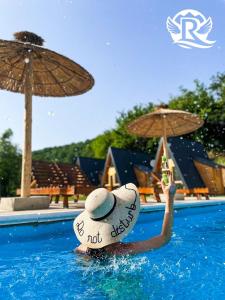 a person in a pool with a hat and an umbrella at Rajska Rijeka in Foča