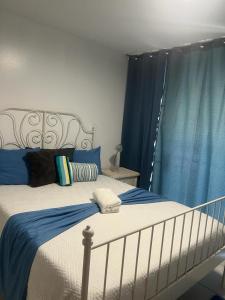 1 dormitorio con cama blanca y cortinas azules en Dorado Beach Condo, en Dorado