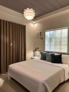 sypialnia z dużym łóżkiem i oknem w obiekcie Japandi Home A - Fully Aircon, WIFI, Hot shower, 24hGuard, Center, near Malls w mieście General Santos