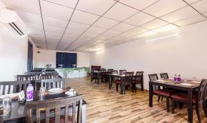 a dining room with wooden tables and chairs at Treebo Trend White Rock - Sohna Road in Gurgaon