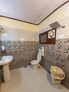 een badkamer met 2 toiletten en een wastafel bij Goroomgo Moon Nainital Near Naini Lake - Parking & Lift Facilities -Hygiene and Spacious Room - Best Seller in Nainital
