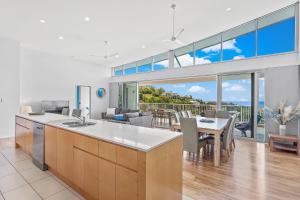 a kitchen and living room with a table and chairs at Coral View at Azure Sea in Airlie Beach