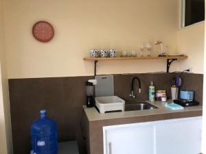 a kitchen with a sink and a clock on the wall at Mini Apartment with terrace in Baños