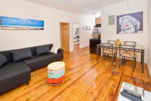ein Wohnzimmer mit einem schwarzen Sofa und einem Tisch in der Unterkunft 102-2A Specious 2BR Best Value Near Cntrl Park in New York