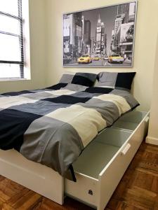 1 cama en un dormitorio con un gran cuadro en la pared en 102-2A Specious 2BR Best Value Near Cntrl Park en Nueva York