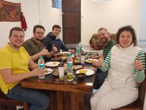 a group of people sitting around a table eating food at The Vantage Haveli in Sawāi Mādhopur