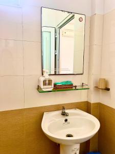 a bathroom with a sink and a mirror at Khách Sạn Chấn Phú Quý in Phú Quý