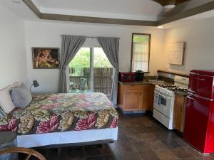 a bedroom with a bed and a red refrigerator at Banyan Tree B&B Retreat in Makawao