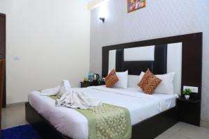 ein Schlafzimmer mit einem großen Bett mit weißer Bettwäsche und Kissen in der Unterkunft Hotel Global Inn By Quality Inn in Neu-Delhi