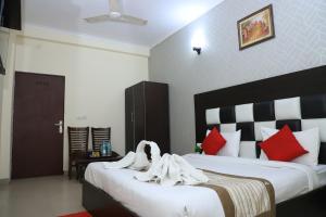 a bedroom with two beds with red and white pillows at Hotel Global Inn By Quality Inn in New Delhi