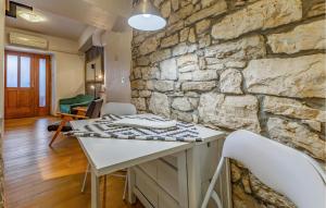een keuken met een stenen muur en een tafel en stoelen bij Nice Home In Fazana With Wifi in Fažana